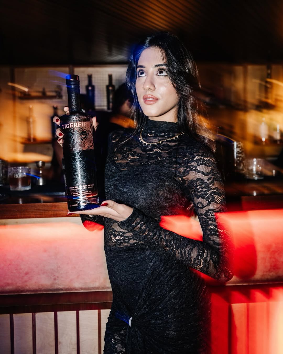 Influencer holding a Tigerfire vodka bottle at the BMW activation